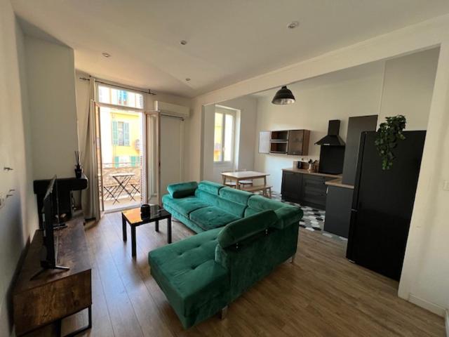 un salon avec un canapé vert et une cuisine dans l'établissement Appartement cosy centre ville NICE, à Nice