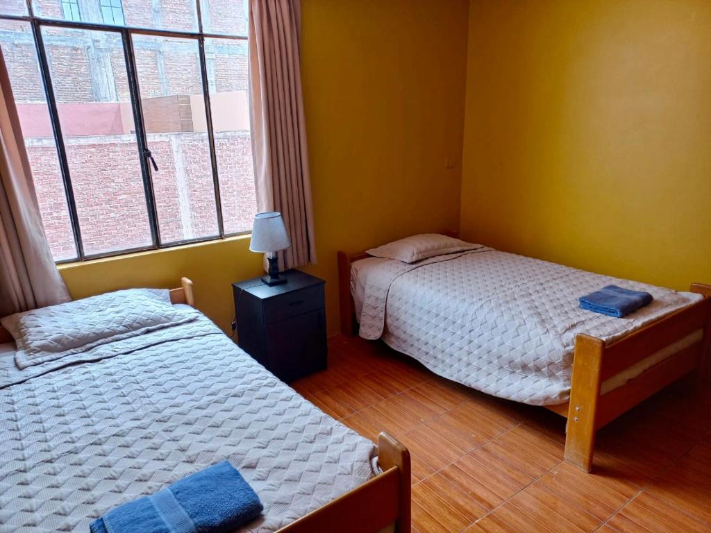 sypialnia z 2 łóżkami i oknem w obiekcie Duplex amoblado en el corazón de Ayacucho w mieście Ayacucho