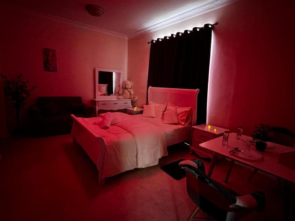 a red bedroom with a bed and a desk and a table sidx sidx sidx at Retreat Haven in Al Ain
