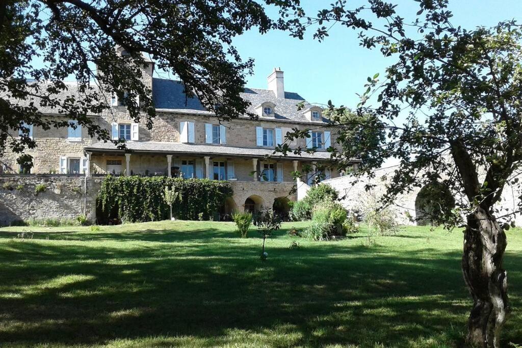 una gran casa de piedra con un árbol en el patio en Le Clos De Soulages gîte 4 personnes, en Palmas