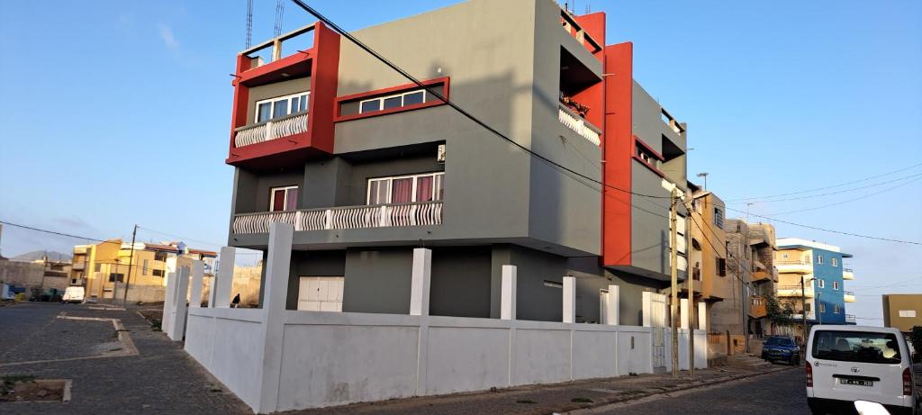um edifício com acentos vermelhos na lateral em Apartamento T1 Mobilado Espargos/Sal em Espargos
