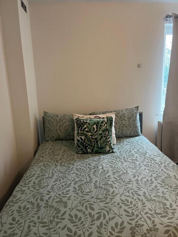 un letto con cuscini in una piccola camera da letto di Juana's private room a Manchester
