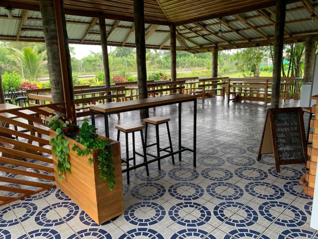 um pavilhão com mesas e cadeiras num piso de azulejo em Hostería Chambira em Puerto Francisco de Orellana