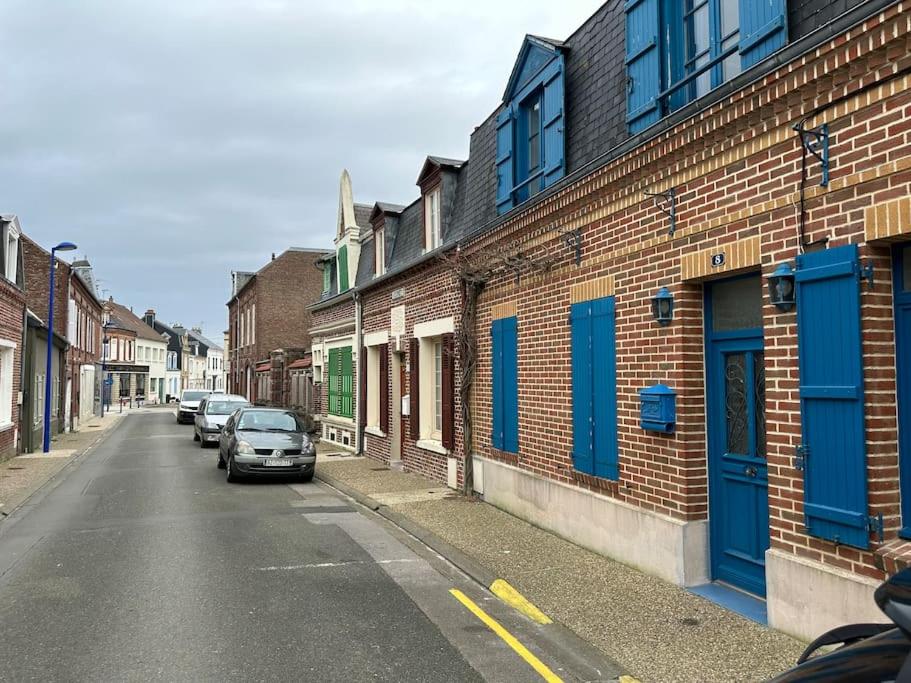 une rue avec des voitures garées sur le côté d'un bâtiment dans l'établissement Gite du Moulin Maison centre ville 4p à 2 pas de la Plage, au Crotoy