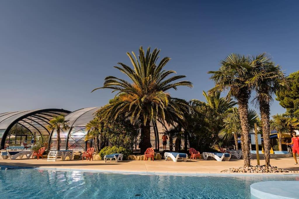 a resort with palm trees and a swimming pool at 469 Emplacement luxe à Mer et Soleil 5* in Les Sables Vignier