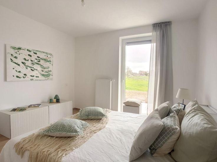 um quarto com uma cama com almofadas e uma janela em Magnifique Appartement Spacieux Liège Centre em Seraing