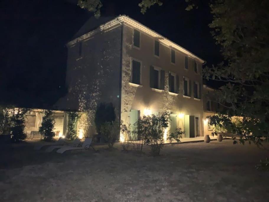 um edifício com luzes de lado à noite em Spacieux Mas Provençale em Sarrians