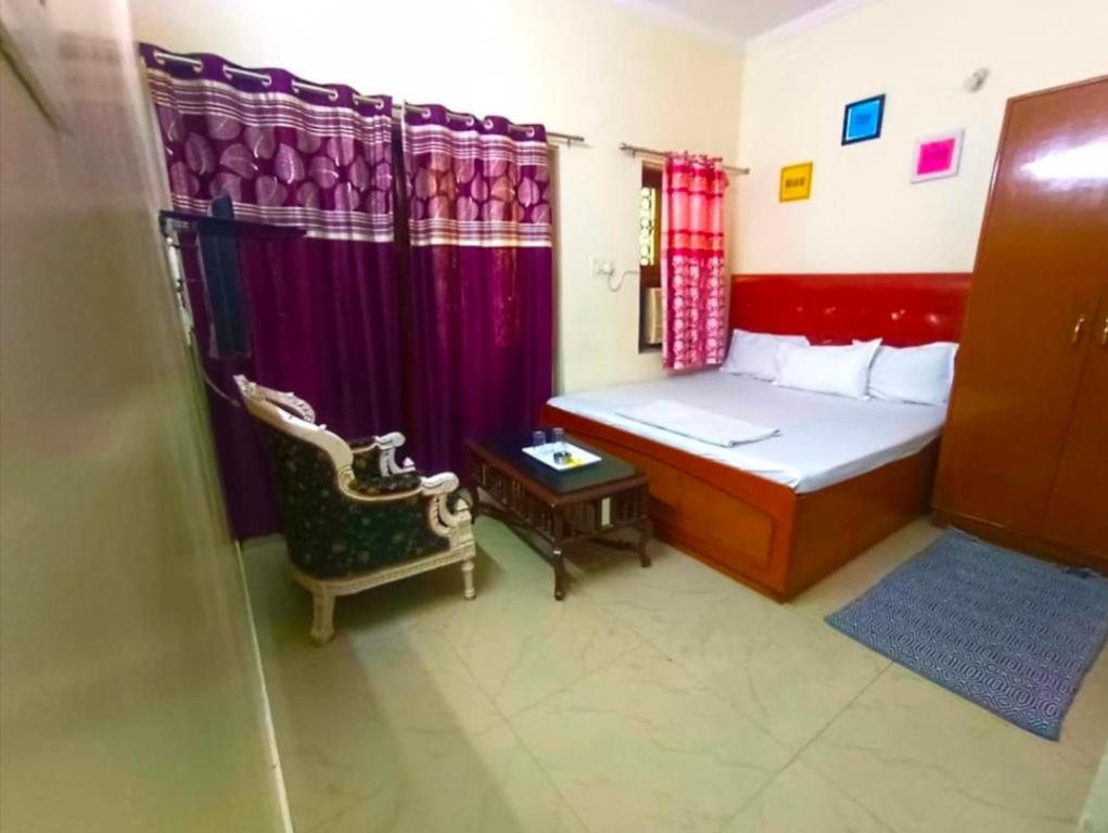 um pequeno quarto com uma cama e uma cadeira em The Super Residency em Nova Deli