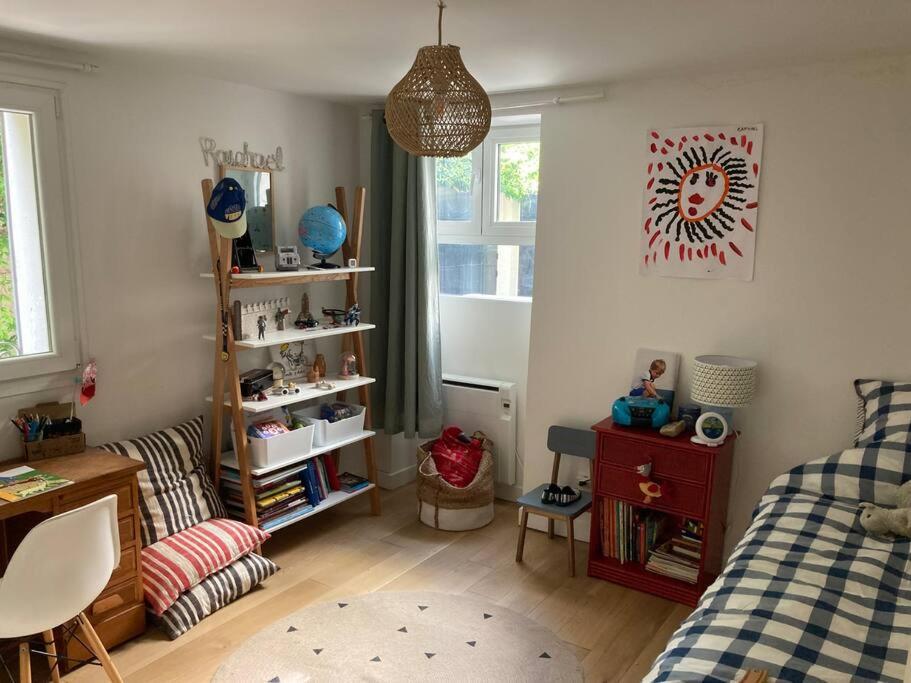 ein Schlafzimmer mit einem Bett, einem Schreibtisch und einem Regal in der Unterkunft Apartment in a charming house in Asnières-sur-Seine