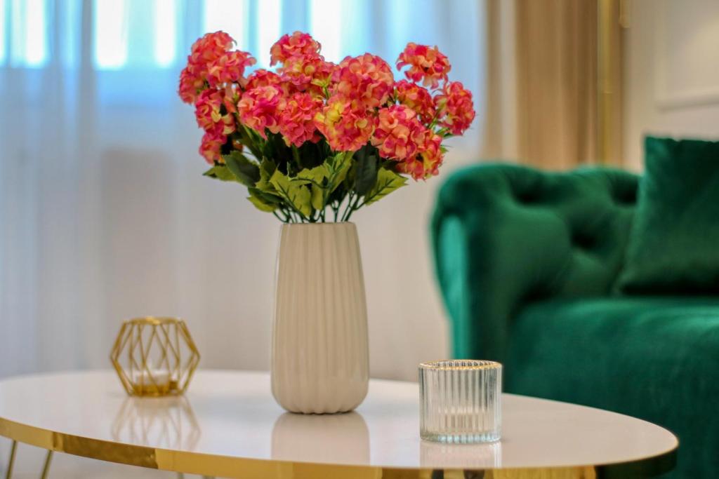 a vase with red flowers sitting on a table at CozyFlat in the central Arad in Arad