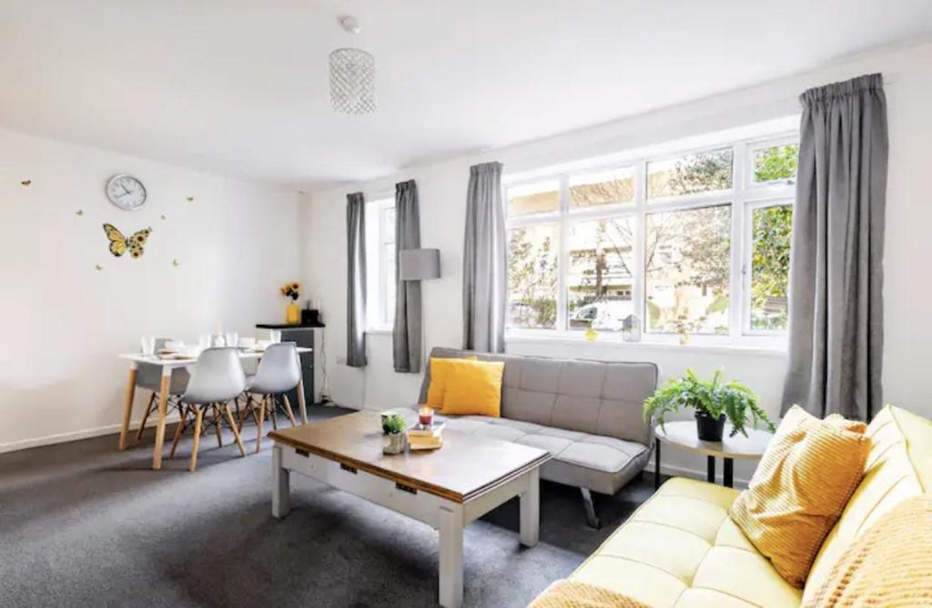 a living room with a couch and a table at Flat in leafy Sale, Manchester in Sale