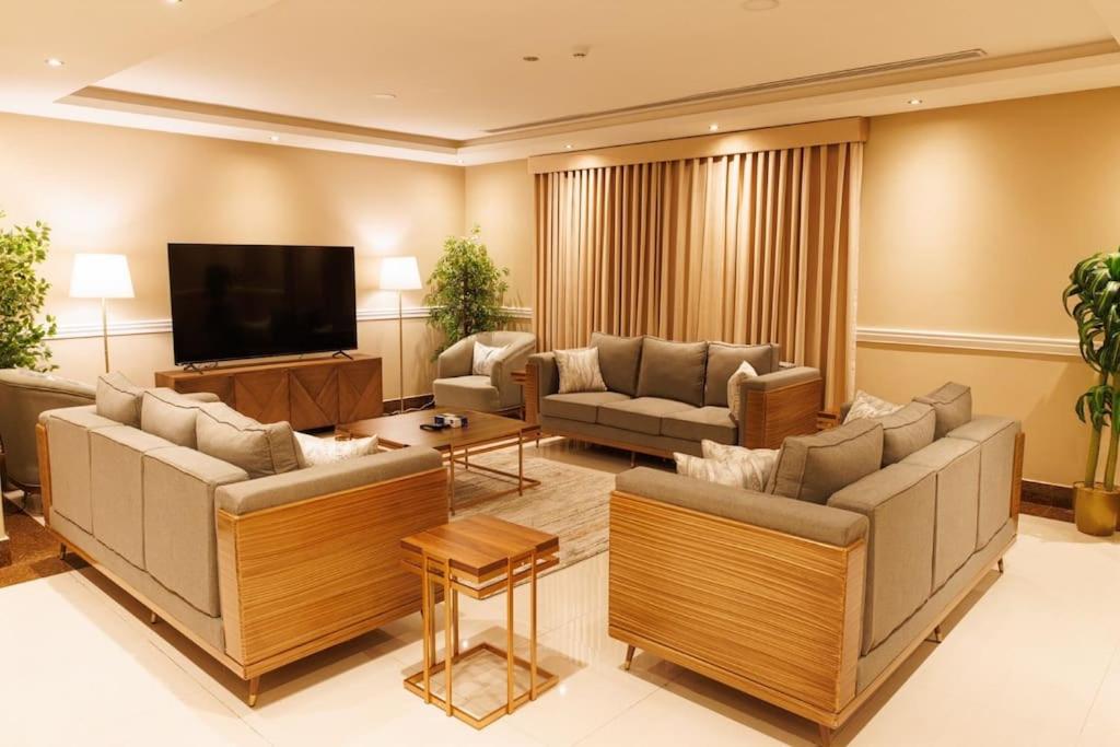 uma sala de estar com sofás e uma televisão de ecrã plano em luxury duplex apartment Alkhobar em Al Khobar