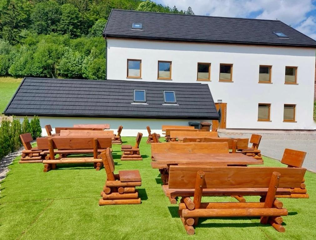 a group of wooden benches in front of a building at Góry Sowie przystanek DAD HOUSE in Sokolec