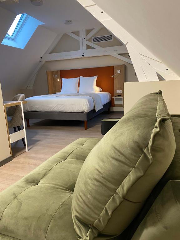 une chambre avec un grand lit dans un grenier dans l'établissement Hôtel du Commerce-restaurant au Couteau, à Nogent