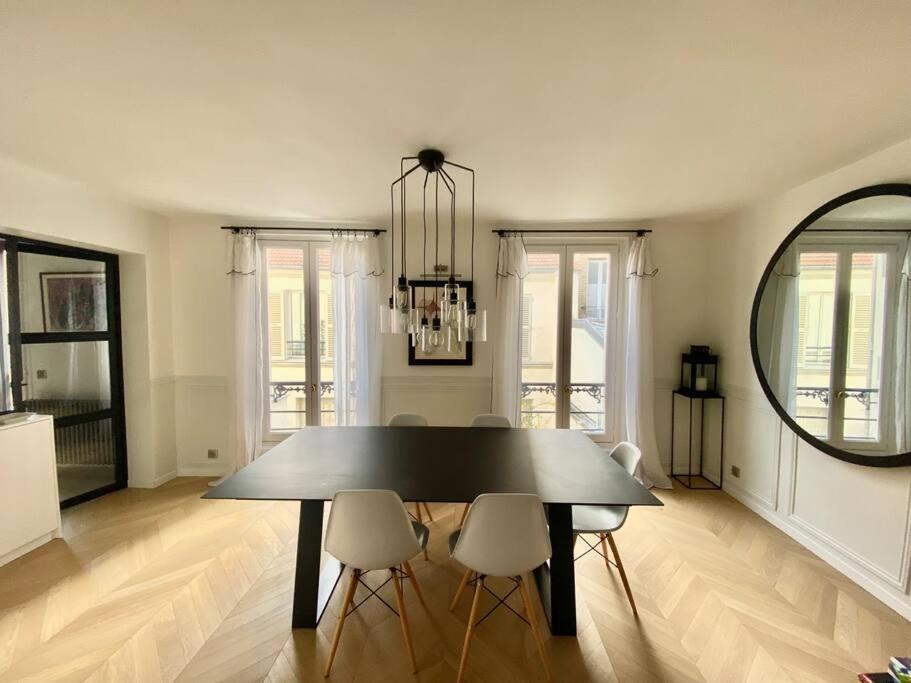 a dining room with a table and chairs and a mirror at Dupleix Boulogne plein centre in Boulogne-Billancourt
