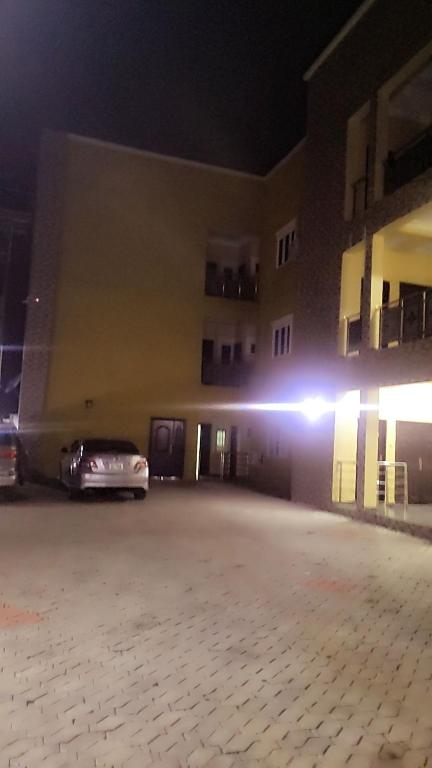 a car parked in front of a building at night at JACKSON'S COURT AND APARTMENT in Rubuchi