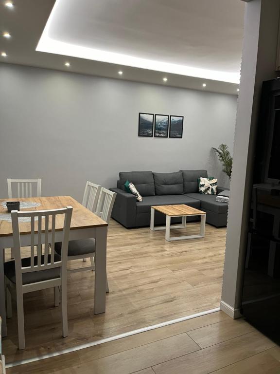 een woonkamer met een tafel en een bank bij Nowoczesny apartament z przestronną łazienką in Stalowa Wola