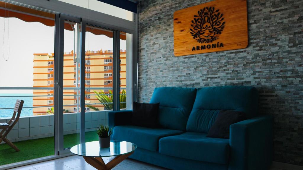 a blue couch in a living room with a view of the ocean at Apartamento Armonía in Candelaria