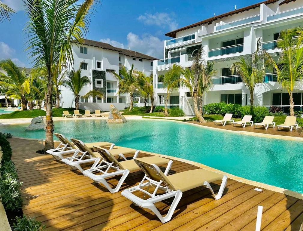 una piscina con tumbonas y un hotel en Beautiful Star of the Caribbean - Apartment Estrella Dominicus Bayahibe, en La Laguna