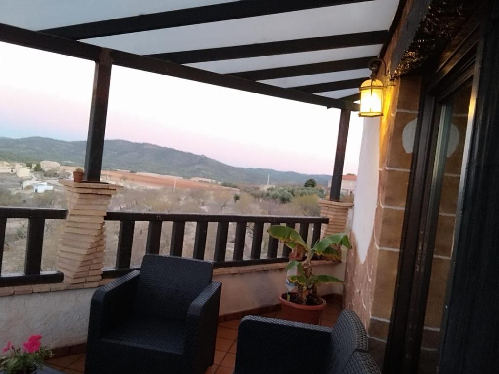 Un balcón con 2 sillas y vistas. en Casa Rural - Vivienda Arado, 