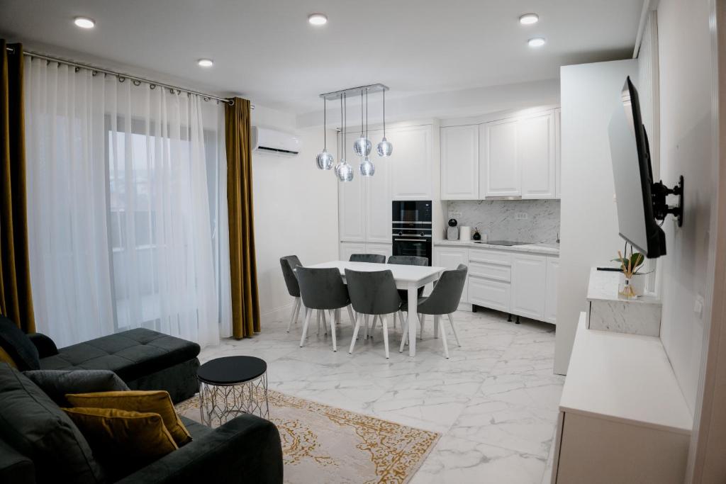 a kitchen and living room with a table and chairs at Oasului Residence in Cluj-Napoca