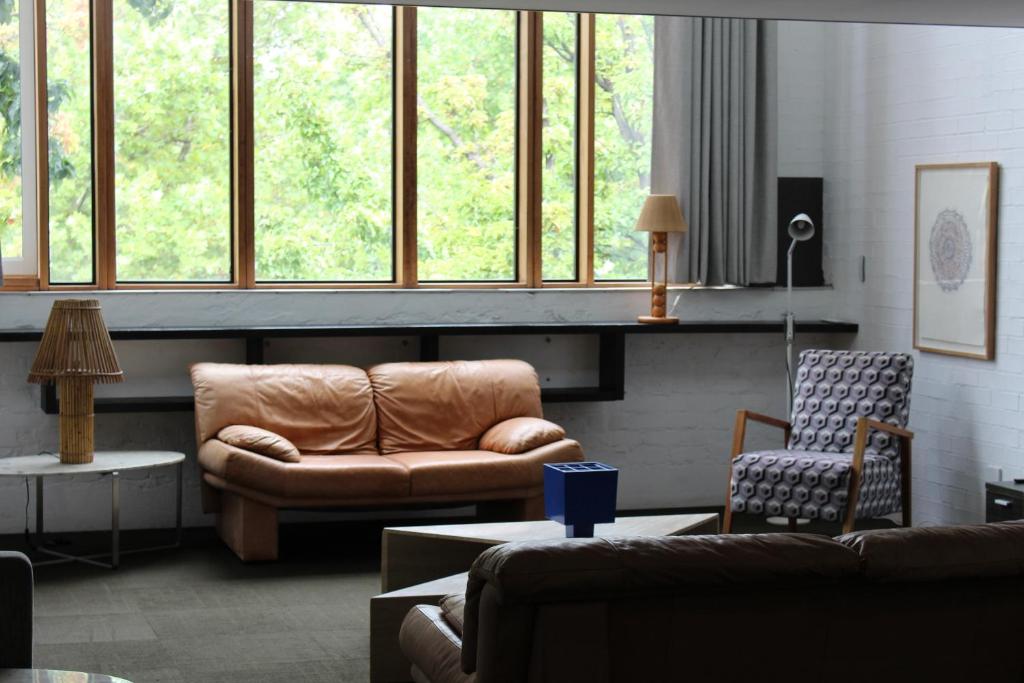 uma sala de estar com um sofá e uma cadeira em Large Bright Modern Loft Apt - Central Location - Suitable for Families and Groups em Narrabundah
