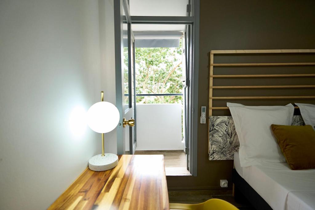 - une chambre avec un lit et une table avec une lampe dans l'établissement La Suite Azur, à Pointe-à-Pitre