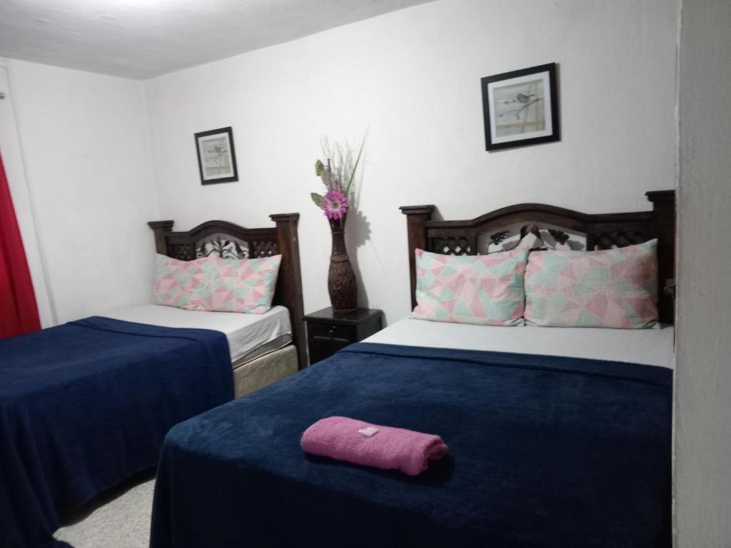 1 dormitorio con 2 camas con sábanas azules y almohada morada en Historico maya, en Guatemala
