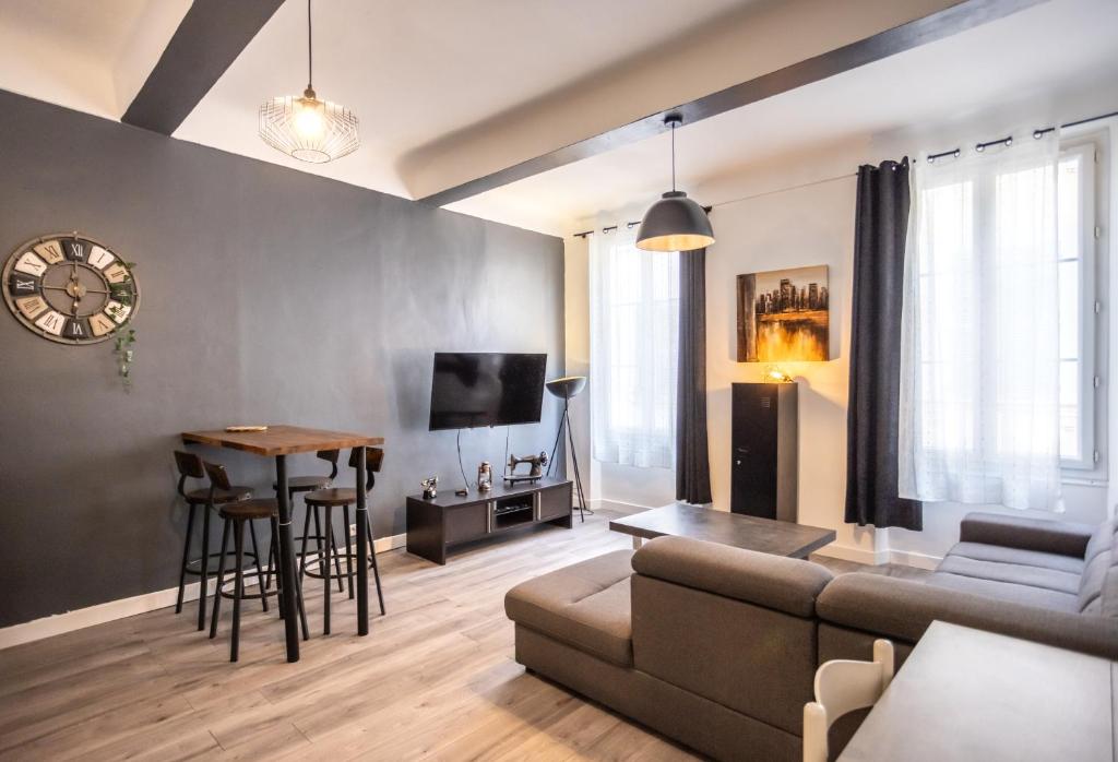 un salon avec un canapé et une table dans l'établissement Appartement cosy au cœur de Toulon, à Toulon