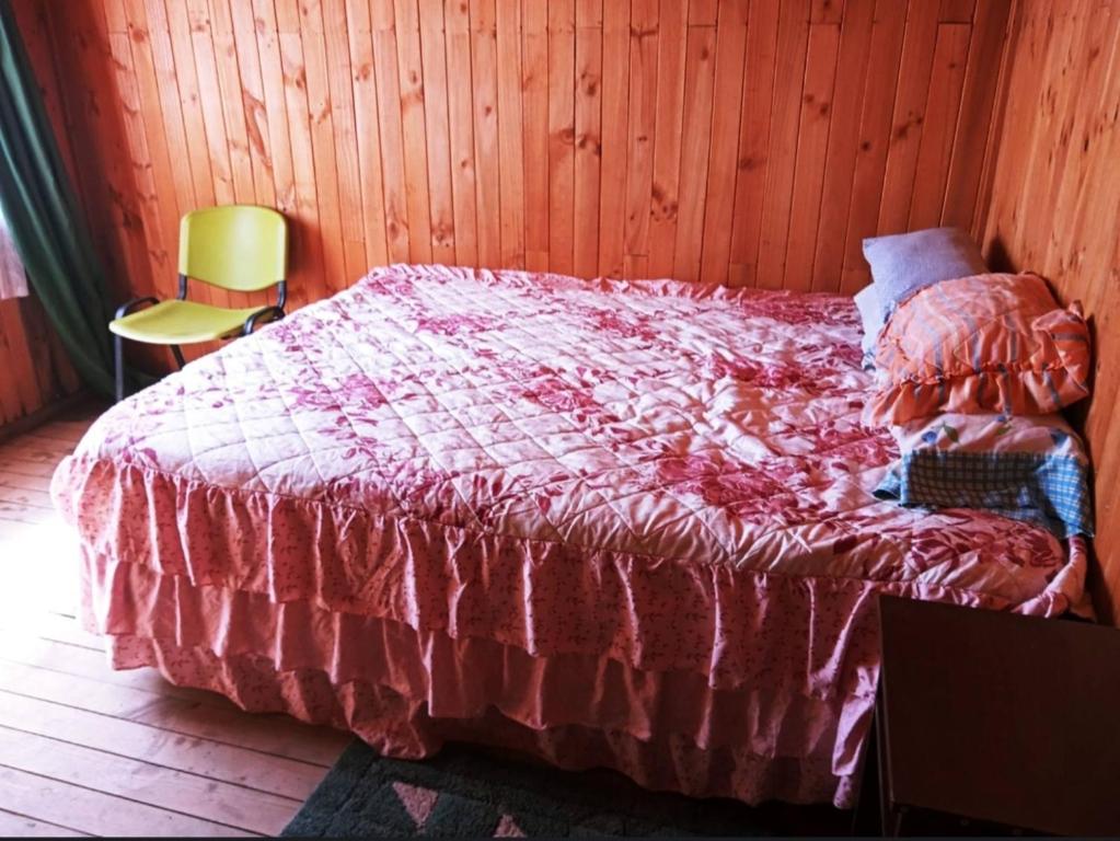 a bedroom with a bed with a red blanket on it at Cabaña Payun in Lonquimay