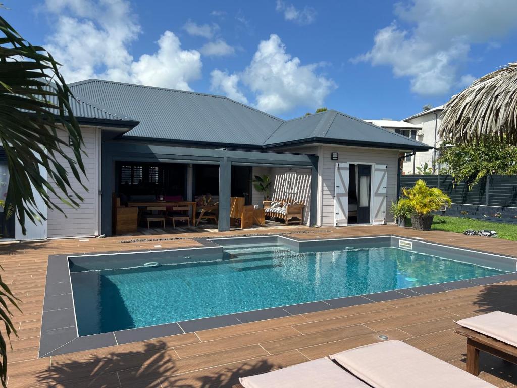 a swimming pool in front of a house at Villa Edna in Sainte-Rose
