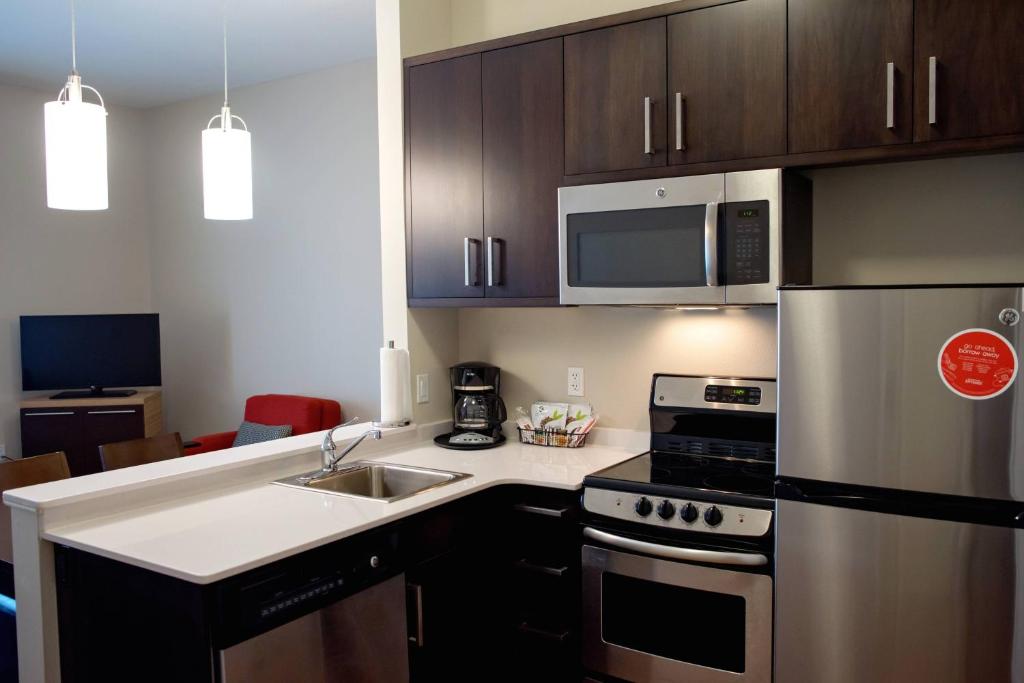 a kitchen with stainless steel appliances and a sink at TownePlace Suites by Marriott Ames in Ames