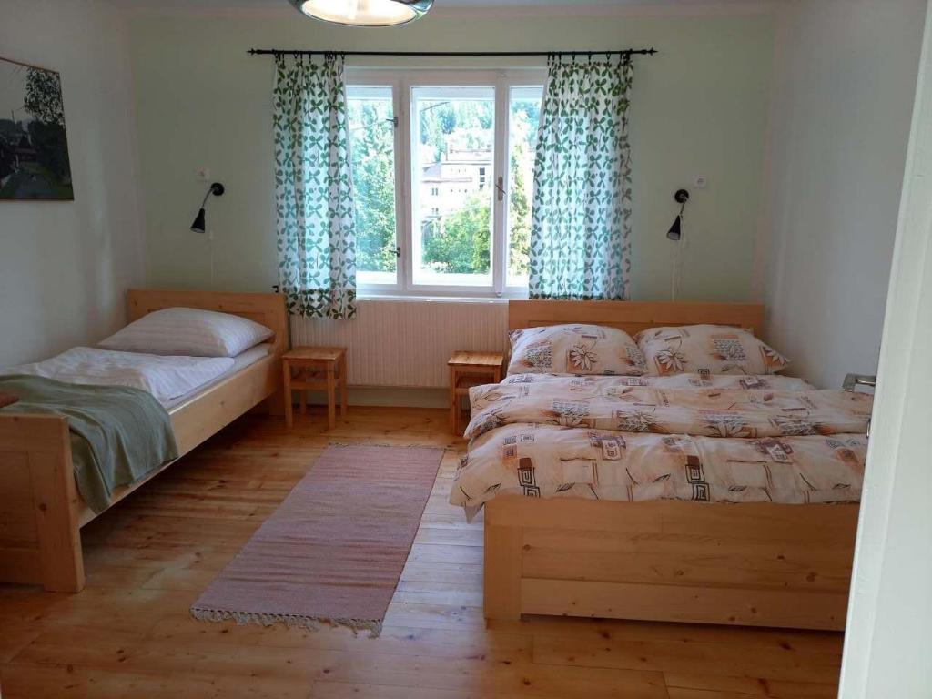 a bedroom with two beds and a window at Dům u splavu in Karolinka