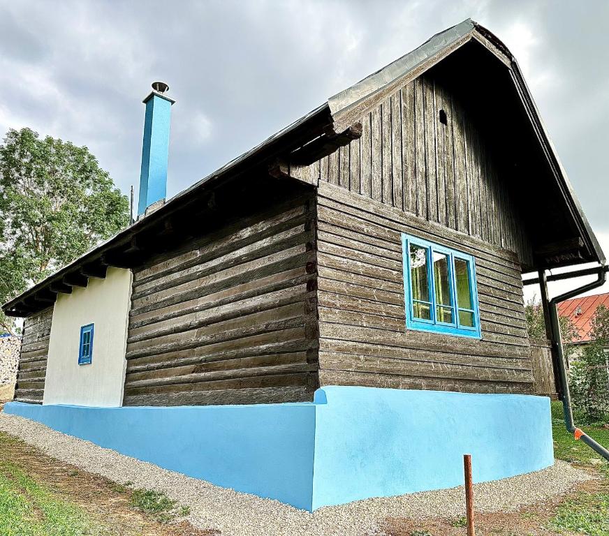a small wooden building with a blue roof at Chata Bottka in Šumiac