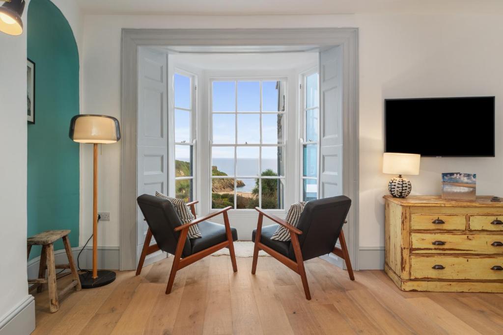 sala de estar con 2 sillas y TV en Windermere - Sea Views Close to Harbour, en Tenby