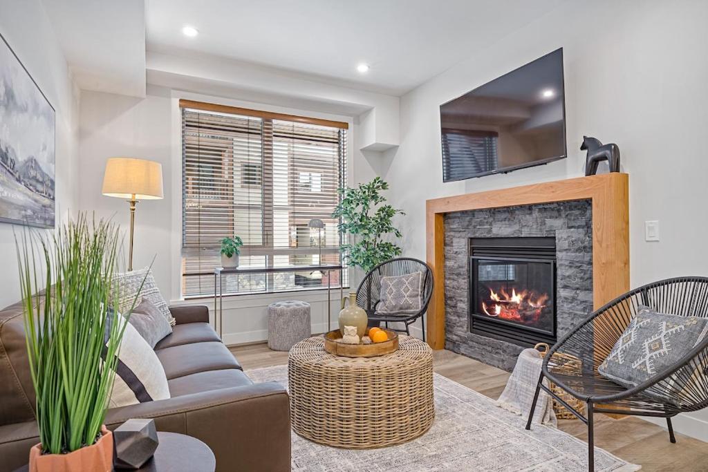 - un salon avec un canapé et une cheminée dans l'établissement Luxurious Vacation Apartment Mountain Scenery, à Canmore
