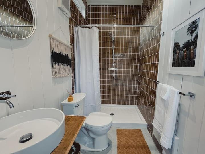 a bathroom with a toilet and a shower and a sink at Dreamy Airstream Hideaway with Hot Tub in Gibsons