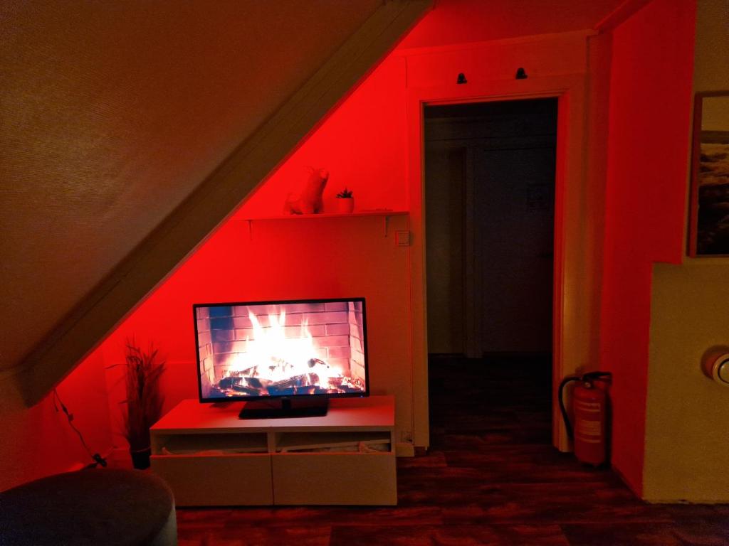 a tv in a room with red lighting at Smaller apartment next to bridge in Tromsø