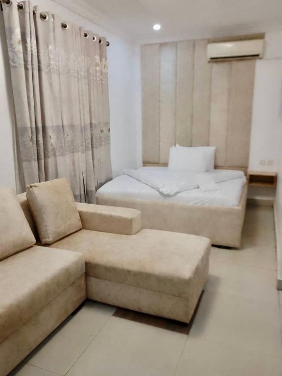 ein Wohnzimmer mit einem Sofa und einem Bett in der Unterkunft Zek’s Place in Ikeja