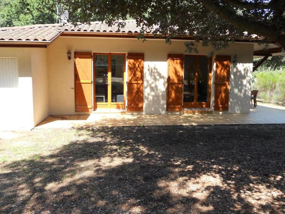 uma casa com portas de madeira e um alpendre em Villa dans quartier résidentiel - V06493 em Soulac-sur-Mer