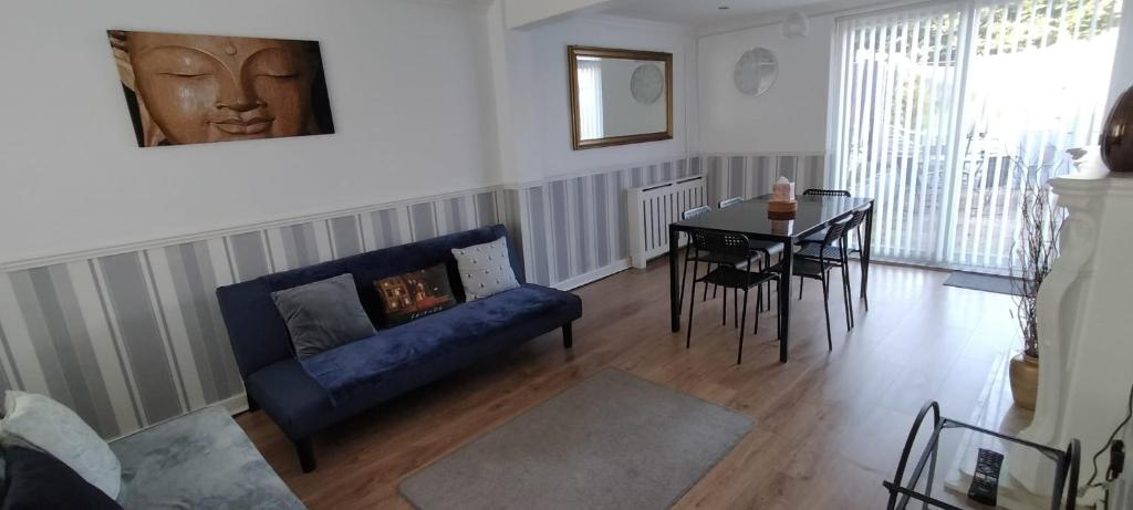 a living room with a blue couch and a table at Ladbury House in Walsall, Near the M6 and near Walsall Manor Hospital, with free parking and easy access to Birmingham city centre, perfect for contractors and families, only 20 minutes from NEC and Birmingham airport in Bescot