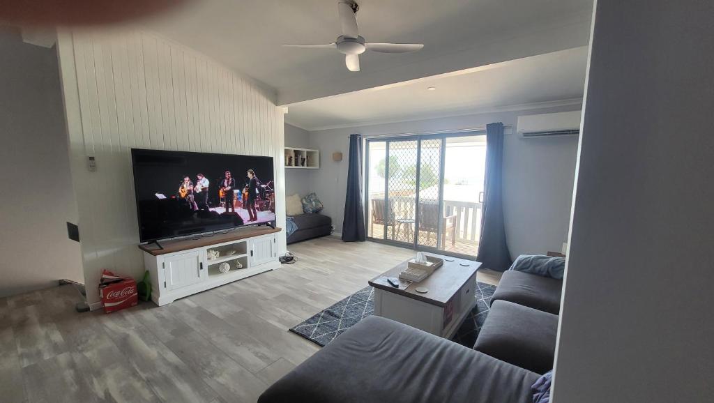 uma sala de estar com uma televisão e um sofá em Kalbarri Sunset Villa em Kalbarri