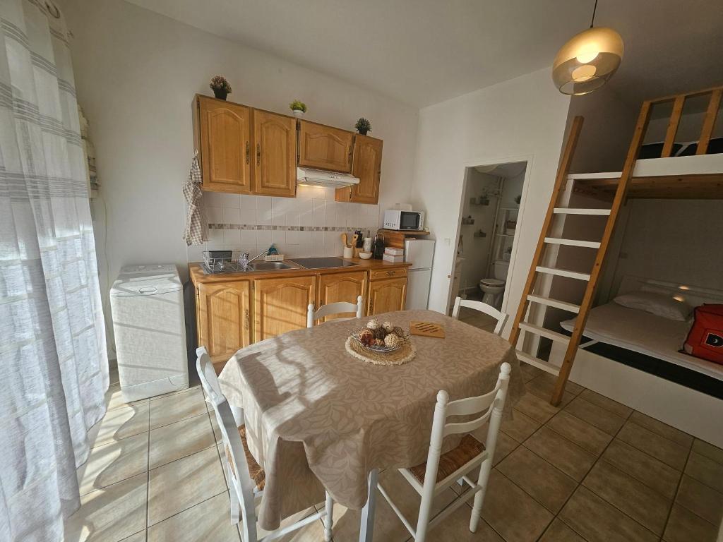 une cuisine et une salle à manger avec une table et des chaises dans l'établissement L'Escale Campanoise, à Campan