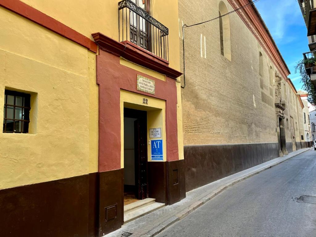 un edificio colorido al lado de una calle en Apartamentos San Francisco, en Sevilla