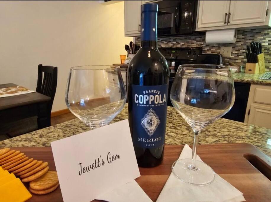 una botella de vino sentada en una mesa con dos copas en Jewett's Gem, en East Jewett