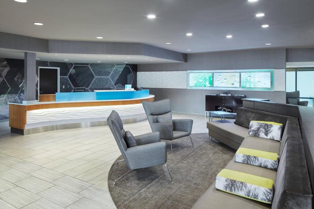 a lobby with a couch and chairs and a bar at SpringHill Suites by Marriott Chicago Bolingbrook in Bolingbrook