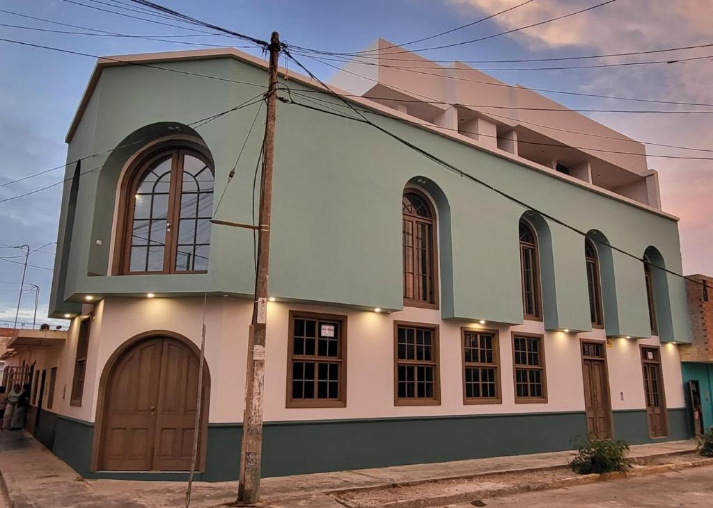 a white and green building on a street at Puerto Malabrigo, Plaza de Armas (Chicama, Peru) in Puerto Chicama