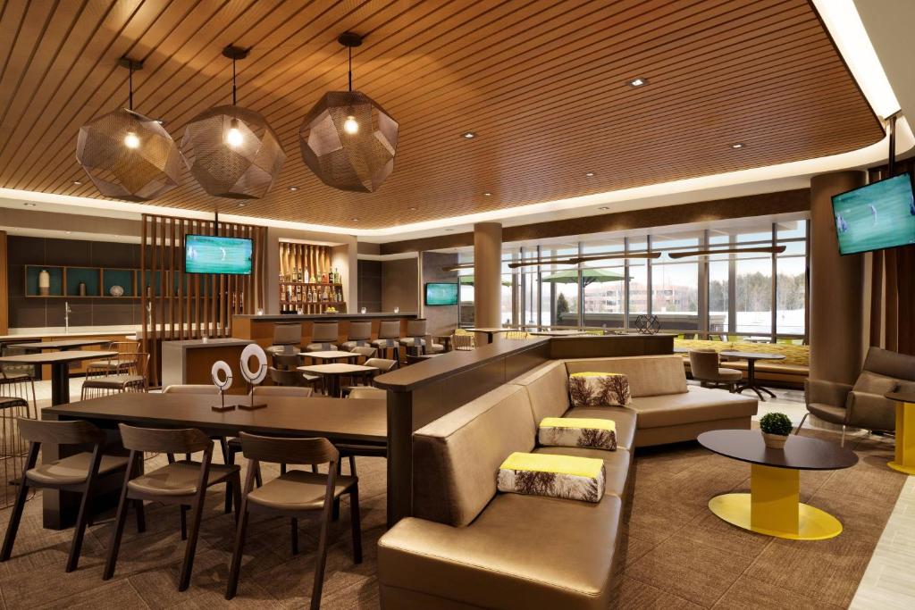 a restaurant with a bar and tables and chairs at SpringHill Suites by Marriott Allentown Bethlehem/Center Valley in Center Valley