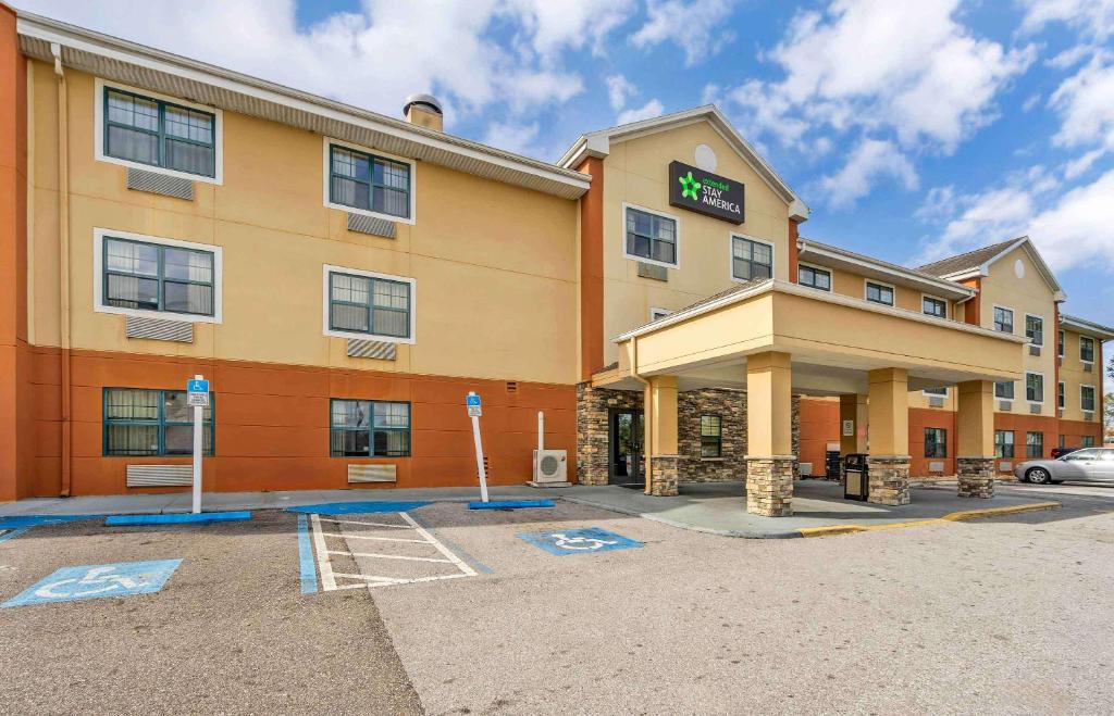 un hotel con un estacionamiento delante de él en Extended Stay America Select Suites - Tampa - North - USF - Attractions, en Tampa