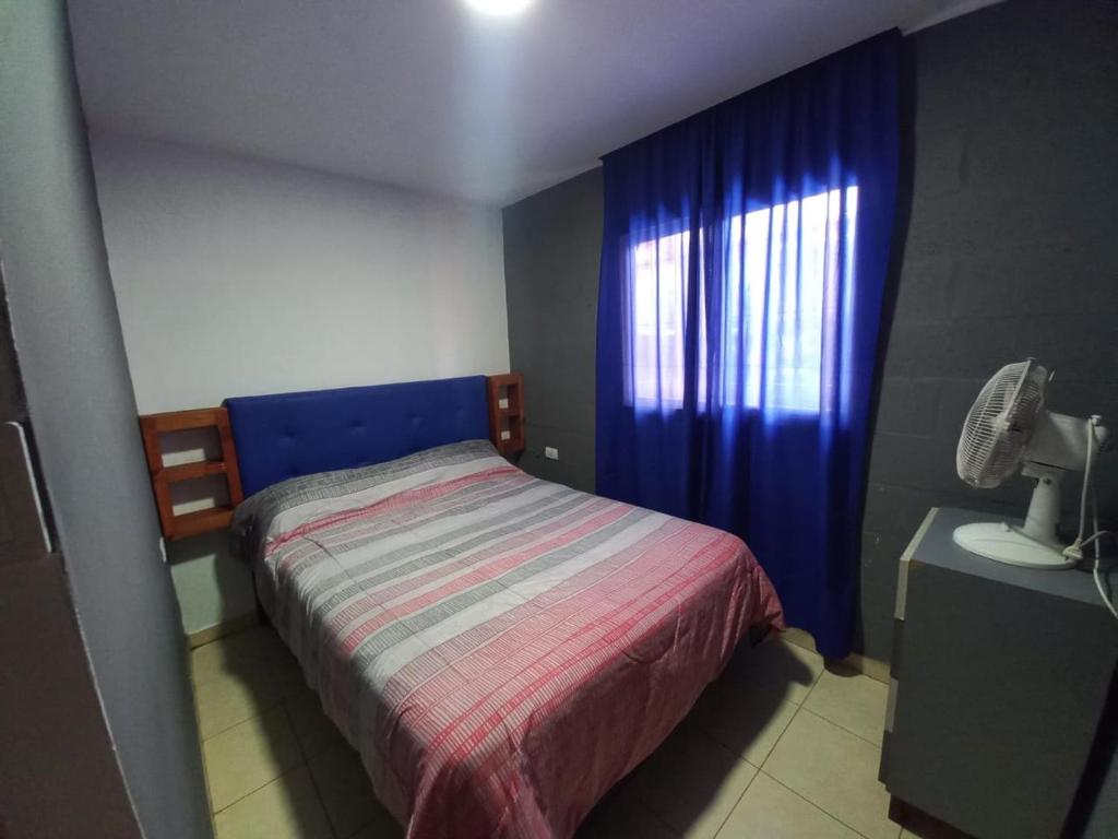 a small bedroom with a bed and a window at Casa de Funes city in Funes
